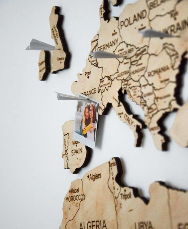 mapa de madera en la pared chinchetas aviones